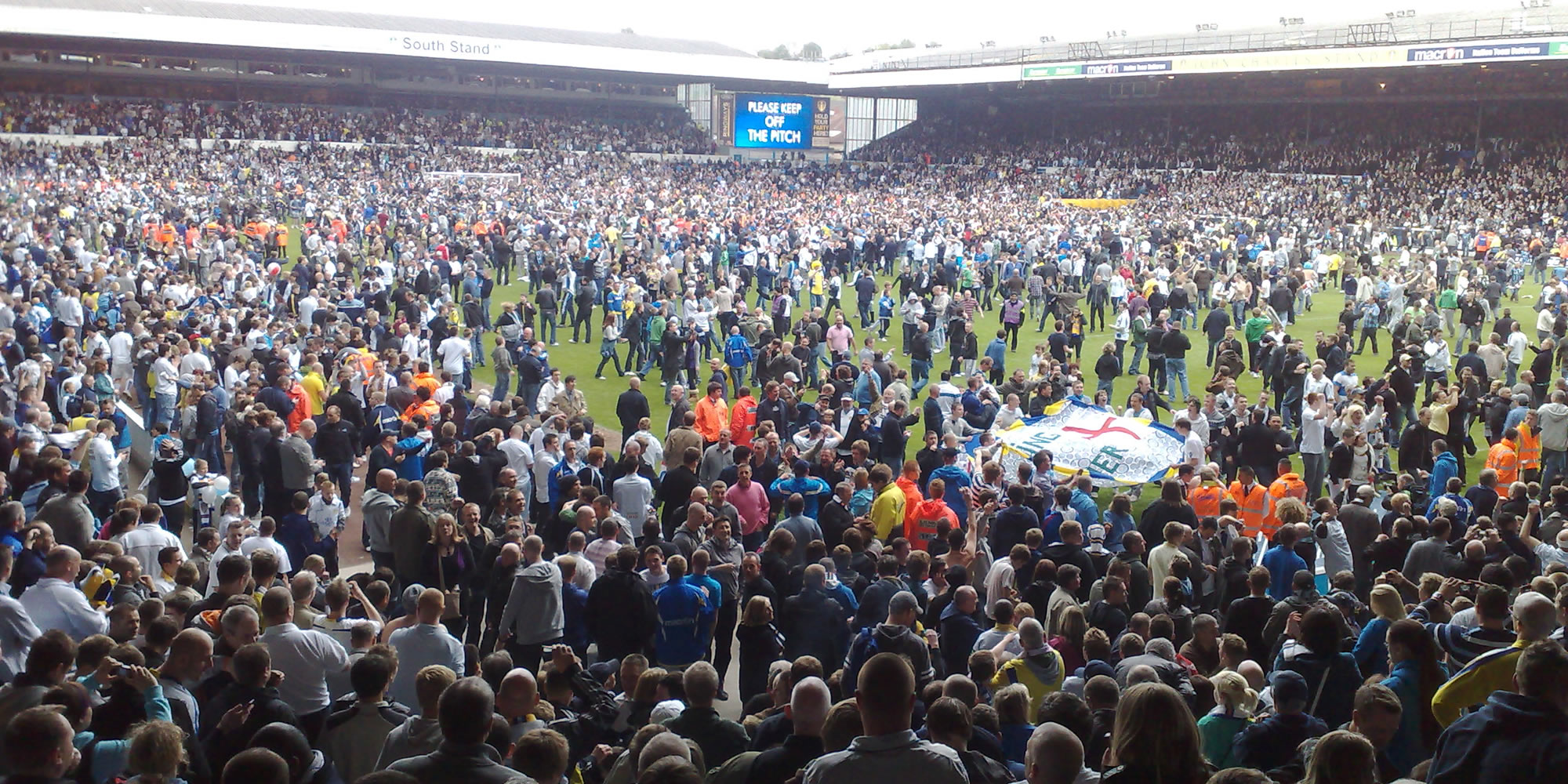 Photo: fans on the pitch at Elland Road.