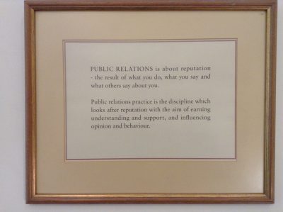 Image of a sign that reads "Public Relations is about reputation - the result of what you do, what you says and what other say about you. Public relations practice is the discipline which looks after reputation with the aim of earning understanding and support, and influencing opinion and behaviour."